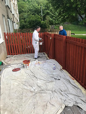 man outside painting fence