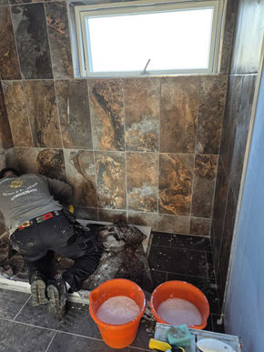 Worker adjusting marble‑like tiles on wall, maintaining symmetry and precision in decorative installation process.
