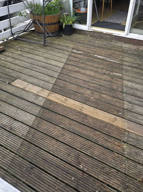 Wooden deck with several planks removed and replaced, showing progress in outdoor renovation and structural improvement