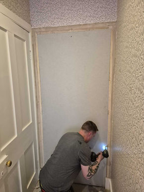 Worker repairing damaged wall with plaster, restoring structure and preparing surface for finishing and decoration.