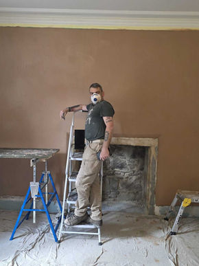 House exterior with white walls and sloped roof, showing completed plastering and clean architectural finish.