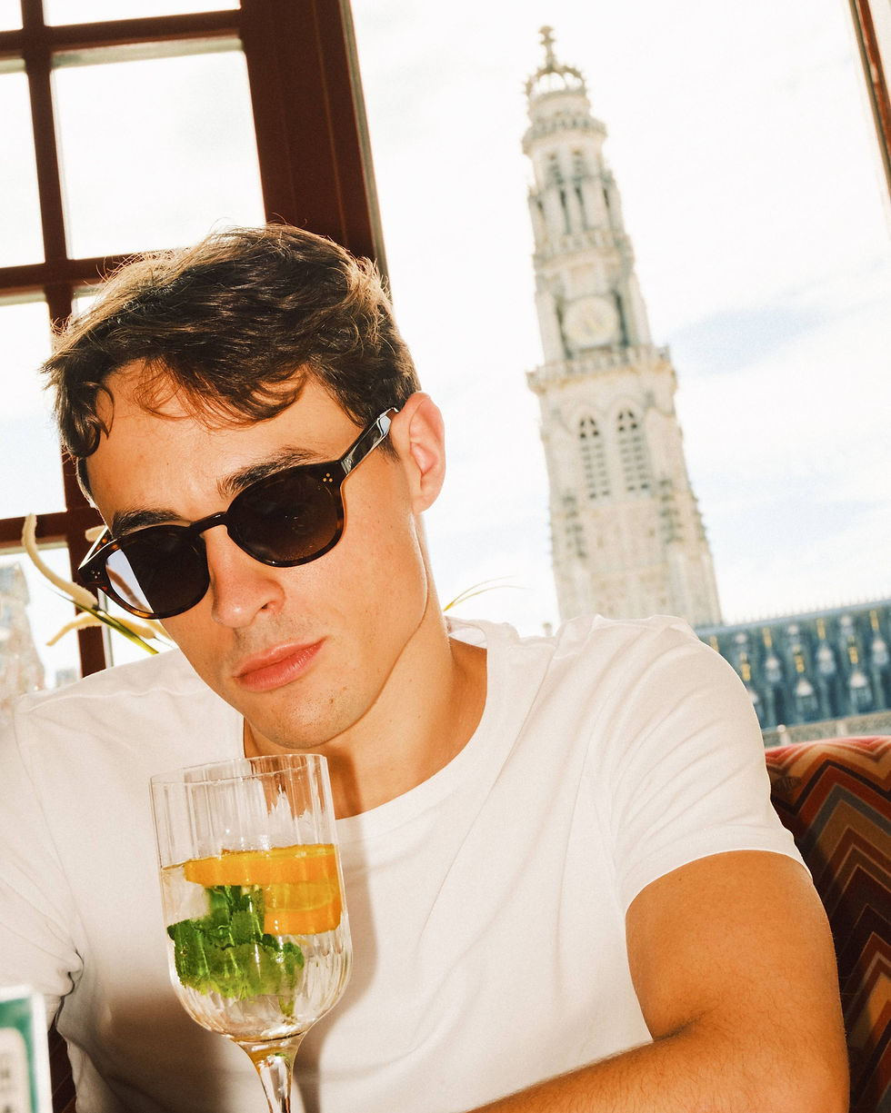 Modèle masculin avec des solaires Aria Optic devant le beffroi d'Arras