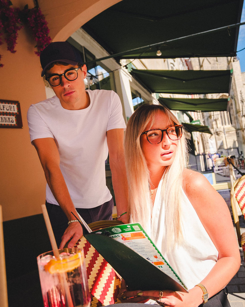Un homme et une femme en terrasse avec des lunettes Aria Optic opticien Arras