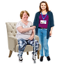 A woman sitting down with a staff member next to her.