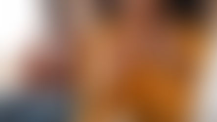 A woman and her spouse sitting a part, considering divorce. The woman is taking her wedding ring off. 