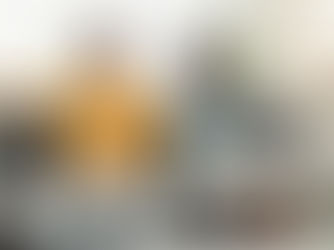 A couple sitting on a couch looking at opposite directions.