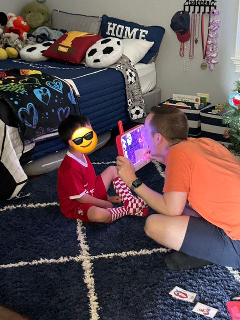 Mr. Wilson and his client are working on articulation skills using a see-through game during play-based speech therapy.