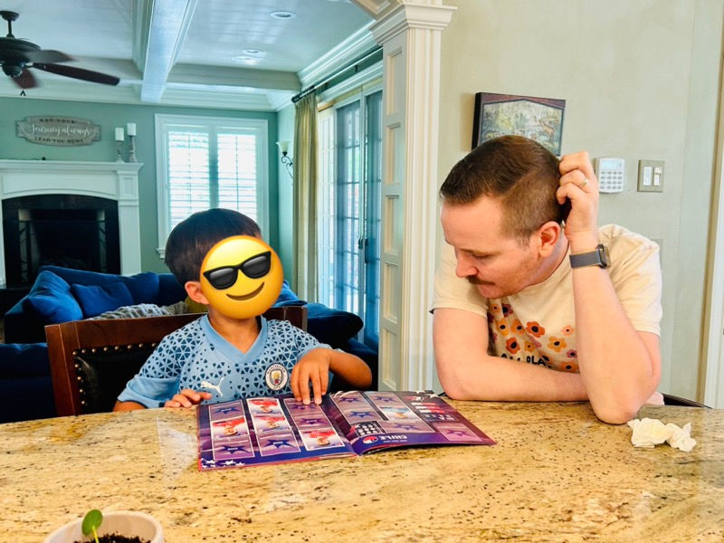 Mr. Wilson is following the child's lead and is using his favorite sports cards to practice articulation skills during an in-home speech therapy session.