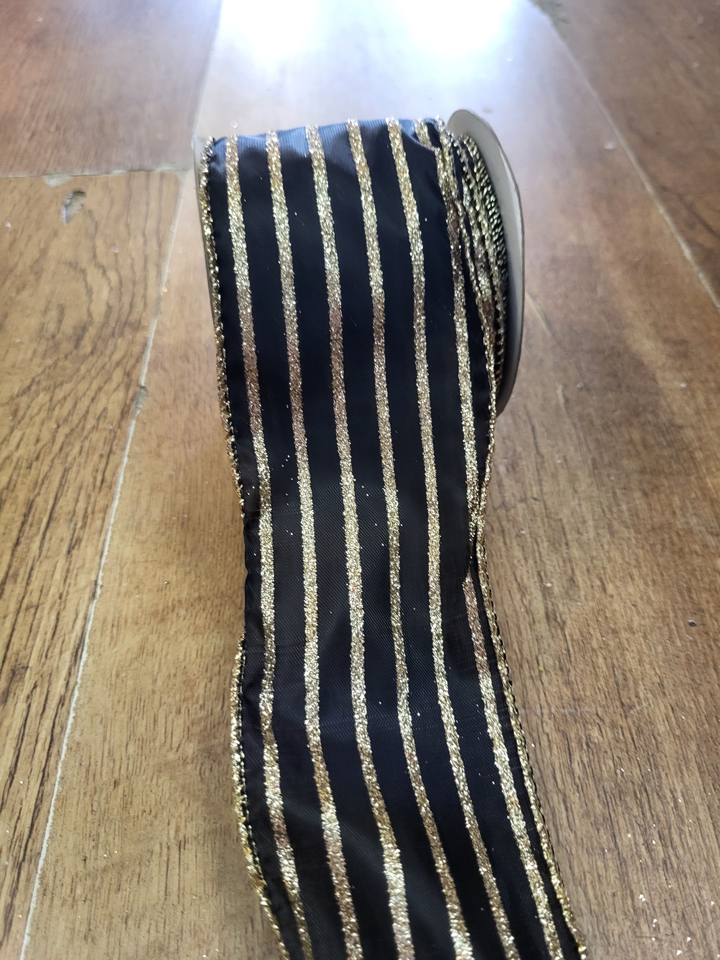 2.7m approx. roll of black with gold glitter striped wired ribbon 