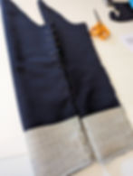 Two coat sleeves pinned ready to be sewn with a pair of scissors in the background