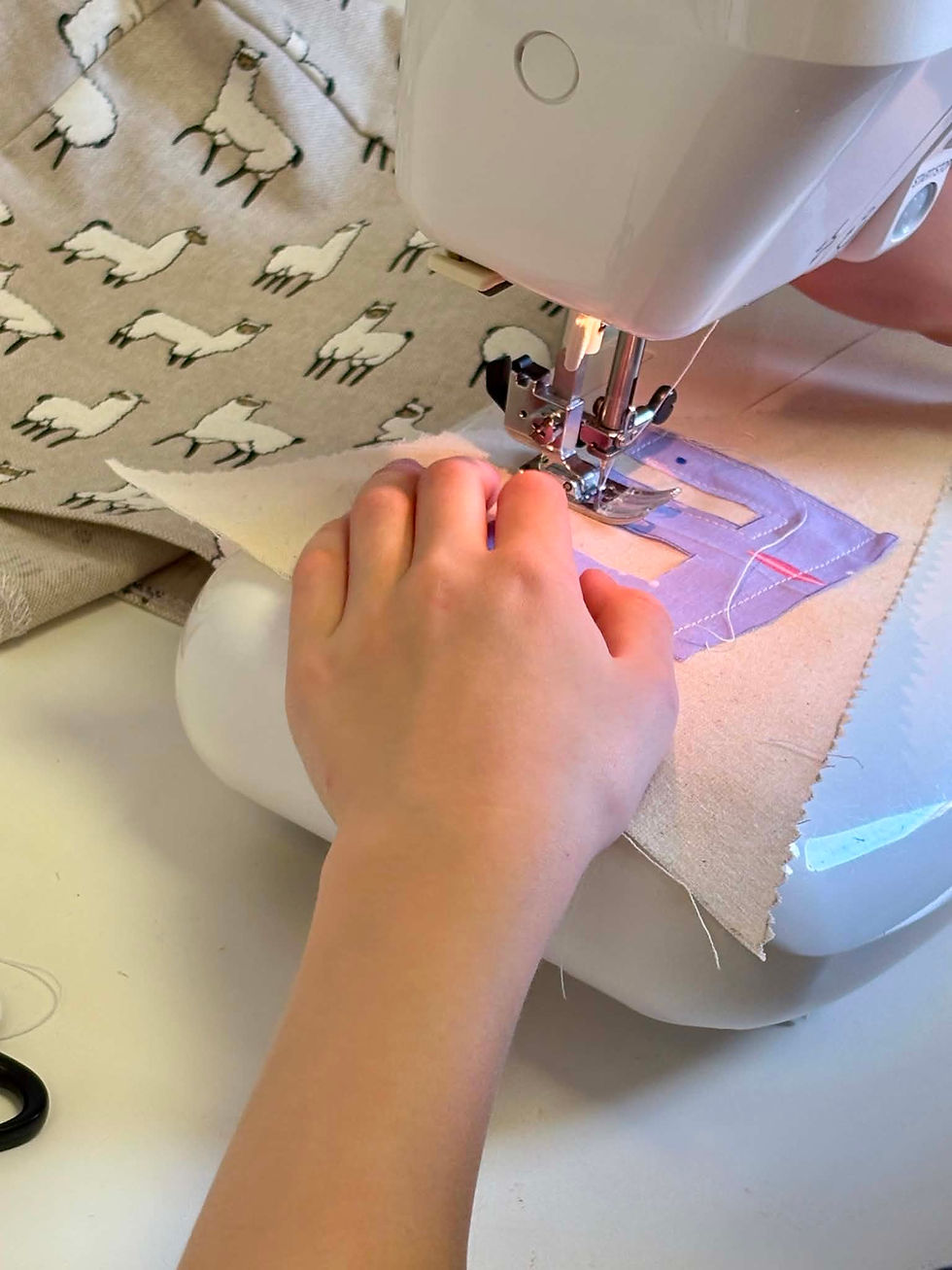 Hands at a sewing machine sewing bunting at a children's sewing party in Harrogate