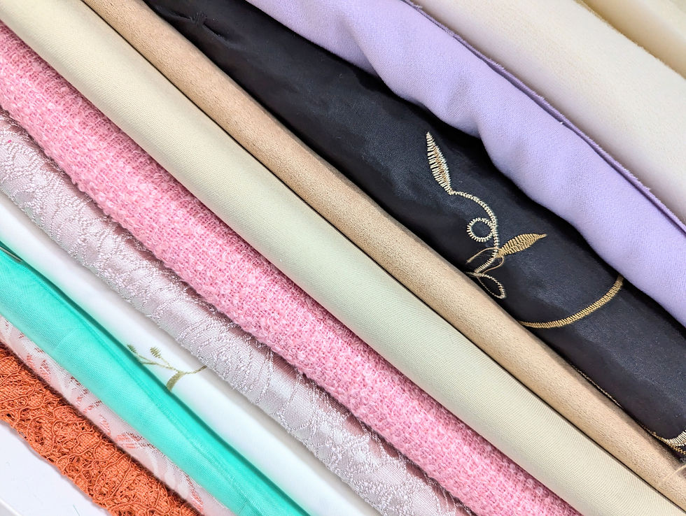 A shelf full of fabric folded neatly in different colours and textures
