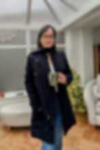 A woman wearing a navy blue handmade coat with a matching scarf