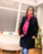 A woman wearing a navy blue handmade coat with a pink scarf