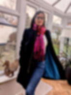 A woman wearing a navy blue handmade coat with a pink scarf
