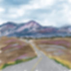 A road leading toward purple mountains.