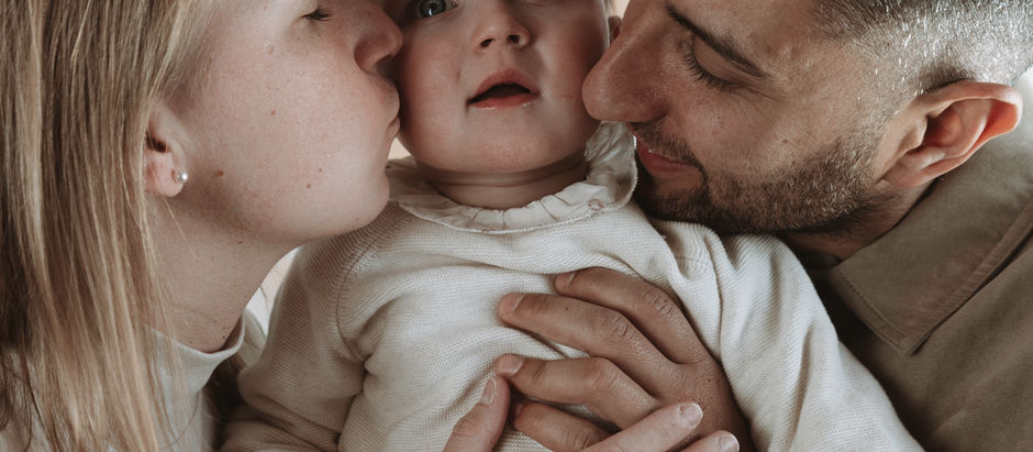 Dos padres abrazando a su hija de un año
