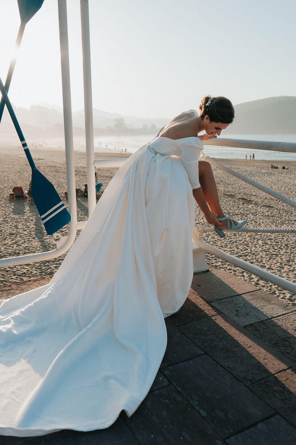 novia ajustándose el zapato en playa de Ribadesella, Asturias