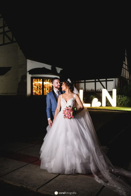 casal de noivos com iniciais ao fundo