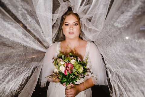 noiva loira deitada com o véu ao fundo