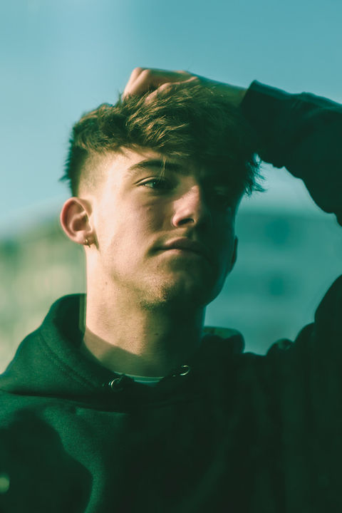 jeune homme dans le reflet d'une vitre par un photographe de portrait à Rennes