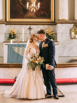 hääpari suutelee alttarilla ennen poiskävelyä