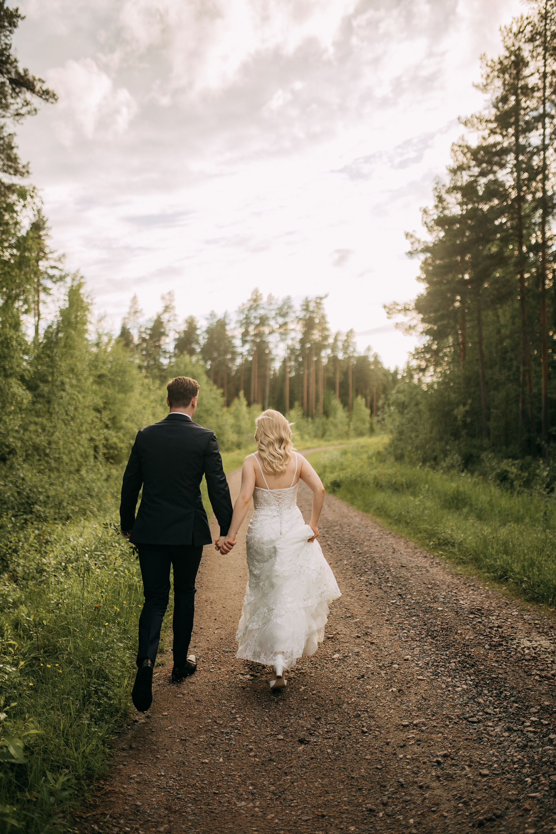 hääpari juoksee kesäillassa