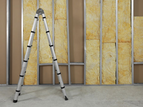 Lone A frame ladder next to an unfinished interior wall