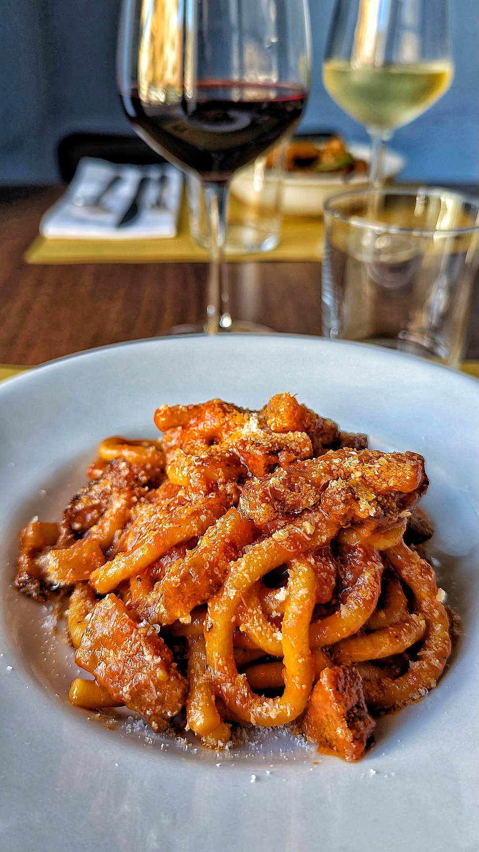 Amatriciana di Menabò con guanciale croccante, pomodoro spezzato a mano e pecorino, preparata secondo la ricetta familiare.