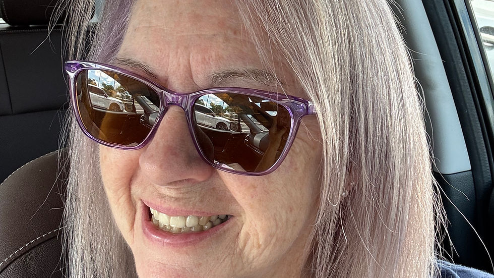 smiling woman with sunglasses and mid-length purple blonde hair