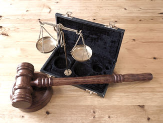 Martelo e Balança, simbolos do judiciário, sob uma mesa de madeira