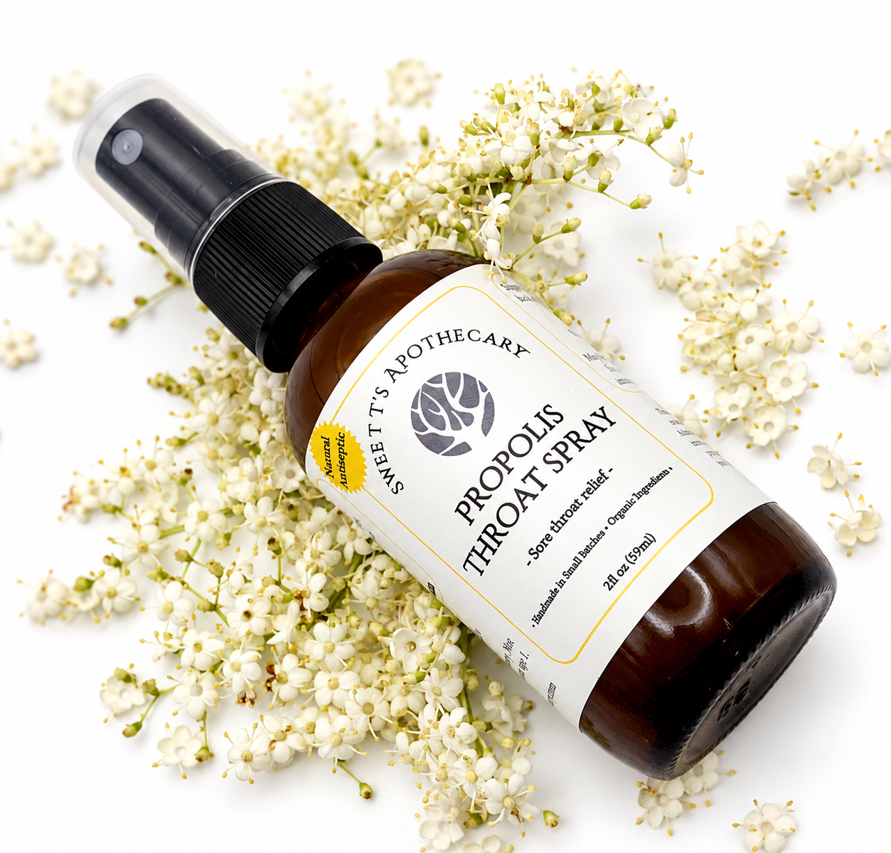 Close-up of the Sweet T's Apothecary Propolis Throat Spray label on an amber glass bottle.