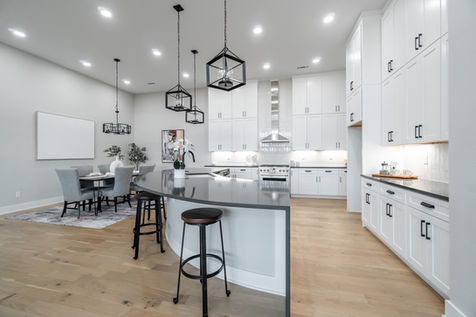 Spacious open kitchen with curved black island and stainless steel appliances in Northwest Arkansas home