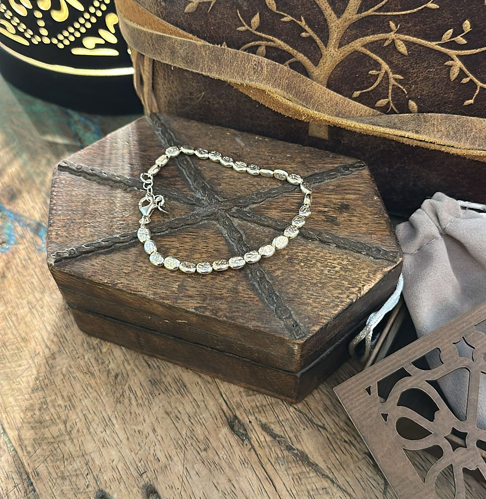 Miniatura: Bracciale in argento 925 con elementi arrotondati e lavorazione raffinata, disposto su una scatola di legno intagliata in sti