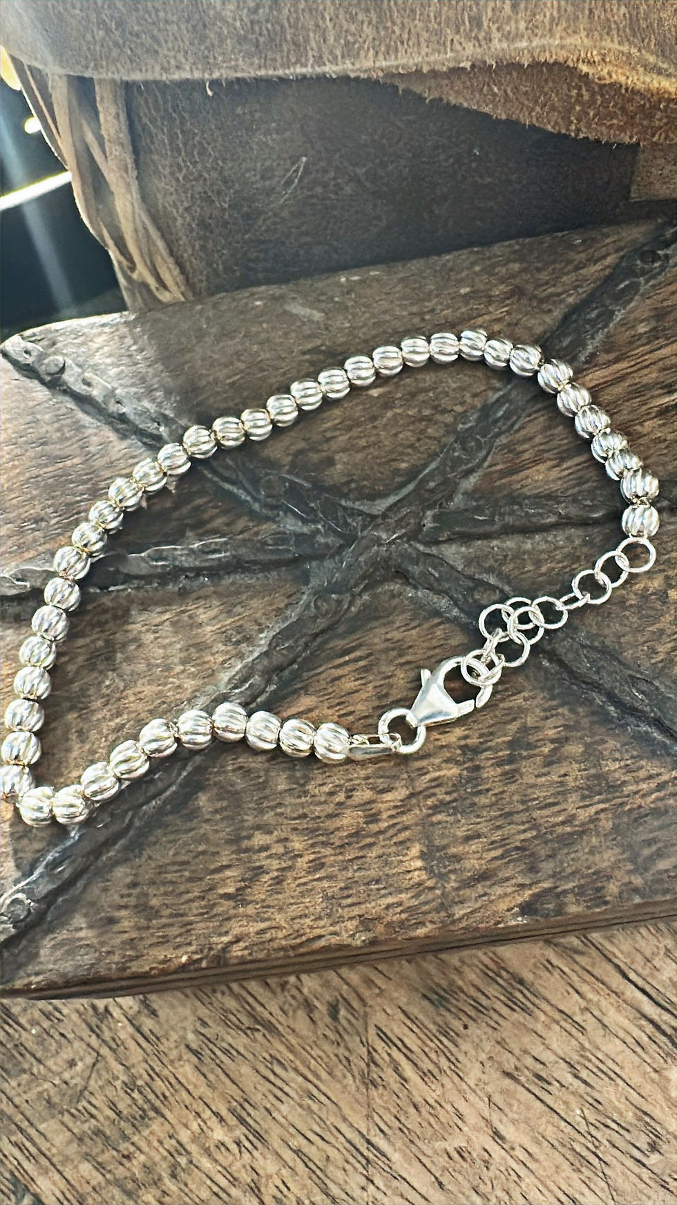 Miniatura: Bracciale in argento 925 composto da piccole sfere lavorate con finitura rigata e riflettente, collegate tra loro in modo fle