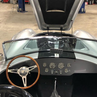 Interior shot of a silver and black shelby cobra.