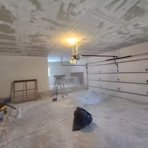 Garage with popcorn ceiling removed and drywall repair in progress