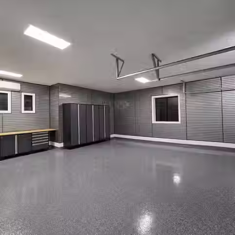 Custom garage with slatwall storage system and NewAge Products cabinets