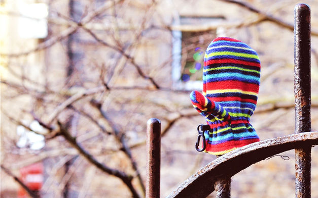 Lost child’s mitten on an iron railing in Edinburgh, part of a photographic series documenting anonymous urban gestures and everyday objects in the city.