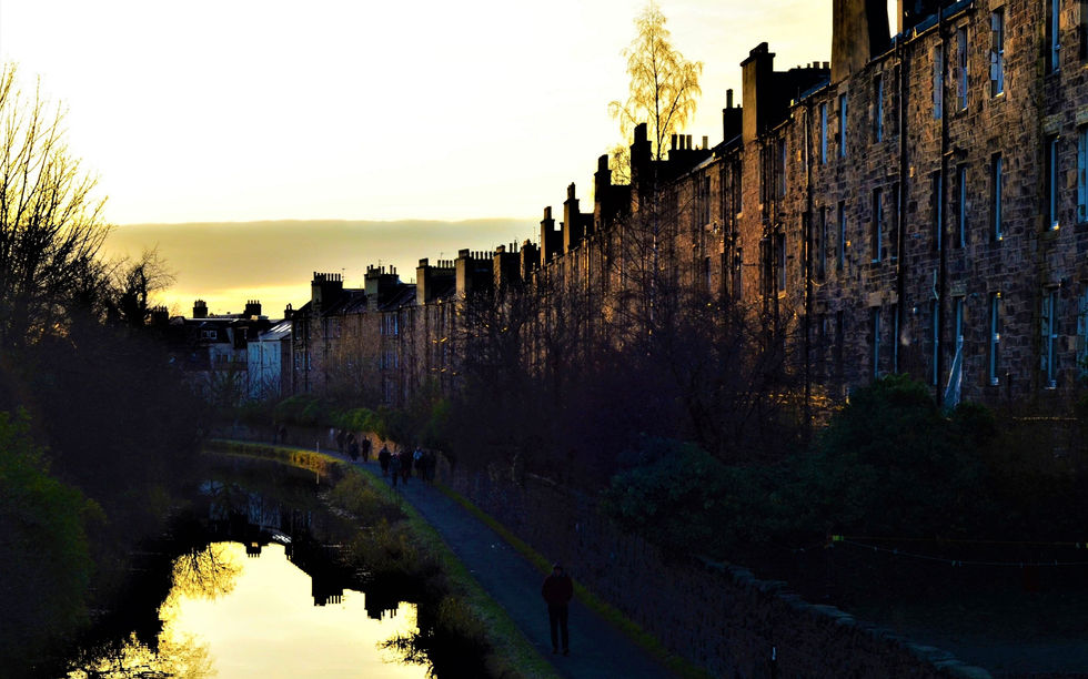 Union Canal, Edinburgh — sunset view from Yeaman Place bridge towards Polwarth, 19th-century canal now used as an urban green corridor with trees, housing, and industrial heritage.