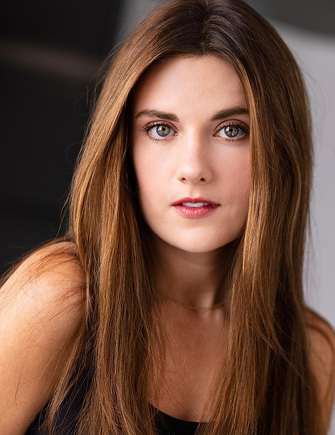 Professional headshot of a young woman with long brown hair, direct gaze.