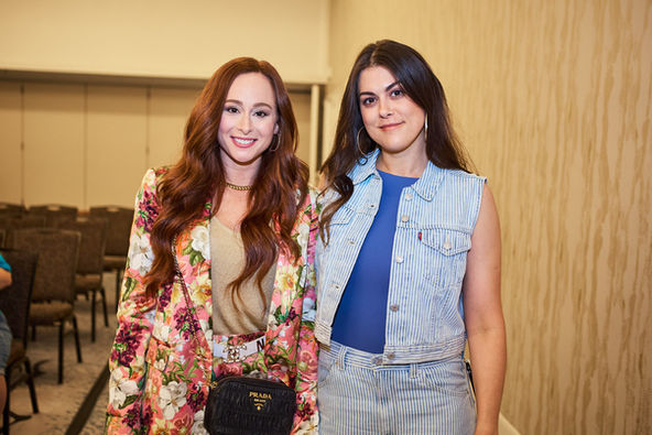 Two female actor hosts posing together in main event ballroom.