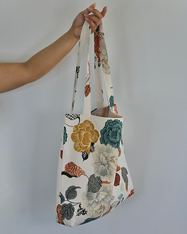 hand carrying a tote bag with flower print.jpeg