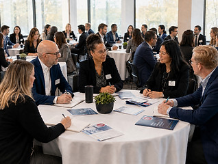 Professionals collaborating at round tables during a customized leadership and development seminar