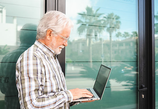 smiling-elderly-businessman-holding-laptop-compute-2024-11-02-22-51-25-utc.jpg