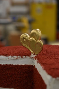 Up close of heart topper on fake red velvet cake.