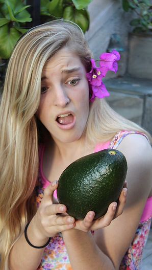 A blond girl shocked by the large size of The Big Mup Avocado