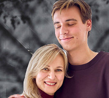 a middle-aged mother hugs grown-up son