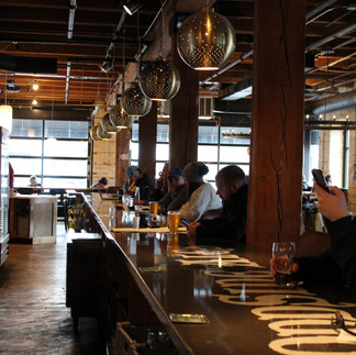 Photo of people sitting at a bar in dark lighting