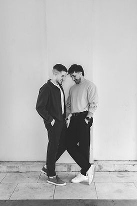 Couple stand together against white wall at Hampstead Heath